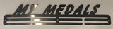 A stainless steel medal display rack with the text 'MY MEDALS' on it, designed to mount on a wall.
